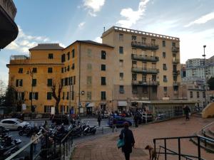 a woman walking a dog in front of a building at Naima 32 in Genoa