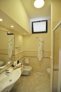 a bathroom with a sink and a toilet and a mirror at Hotel Airone isola d'Elba in Portoferraio