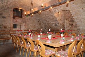 a long table in a stone room with chairs and a tableablish at Hotel Steakhouse Am Rathaus in Tann