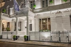 a white building with a fence in front of it at Roseate House London in London