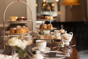 a table with three tiers of pastries and desserts on plates at Roseate House London in London