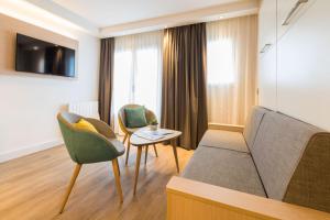 a living room with a couch and two chairs at Résidence Neptunia in Saint Malo