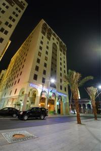 a large building with a car parked in front of it at Manazeli Madinah in Medina