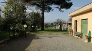 un vialetto di ghiaia con una panchina accanto a un edificio di Appartamento Tuscany a Cenaia