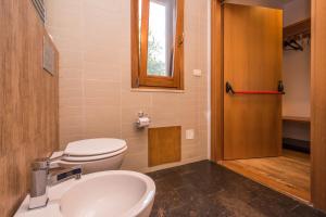 a bathroom with a toilet and a sink and a window at B&B Le Dune - Self Check in in Lascari