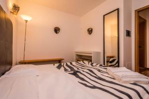 a bedroom with a large white bed with a mirror at B&B Le Dune - Self Check in in Lascari
