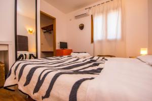 a large bed with a black and white striped blanket at B&B Le Dune - Self Check in in Lascari