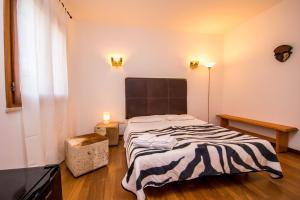 a bedroom with a bed with a striped blanket on it at B&B Le Dune - Self Check in in Lascari