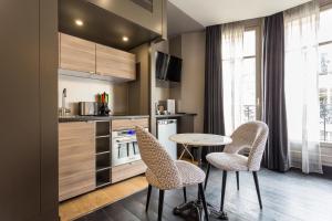 a kitchen with a table and chairs in a room at CMG - Deluxe Tour Eiffel - 42 in Paris