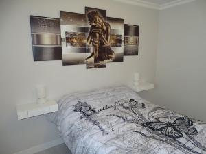 una camera con un letto con immagini appese al muro di Casasjerezanas Mariposa a Jerez de la Frontera