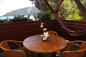 a wooden table with a flower arrangement on a deck at Résidence Mobydick in Porto-Vecchio