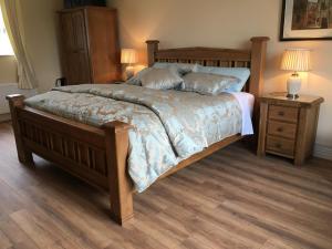 a bedroom with a bed and a night stand with two lamps at Grove House Bed & Breakfast in Carlingford