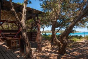 a tree house with a hammock and two trees at Résidence Mobydick in Porto-Vecchio
