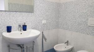 biała łazienka z umywalką i toaletą w obiekcie B&B Le Due Corti w mieście Martignano