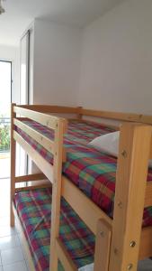 een slaapkamer met een stapelbed en een gestreepte deken bij Résidence AZUR1 Appartement 251 in Le Lavandou