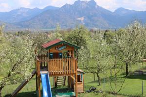 a tree house in a field with mountains in the background at Pension Berghof in Brannenburg