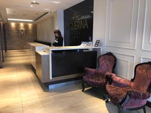 eine Frau, die an einem Tresen in einem Salon mit Stühlen steht in der Unterkunft Gran Hotel Miglierina in Mar del Plata