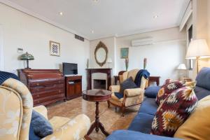 sala de estar con sofá azul y sillas en Amplio&Luminoso Triana en Sevilla