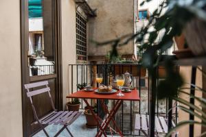 uma mesa numa varanda com dois copos de vinho em B&B Malvasia em Palermo