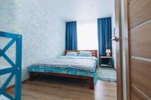 スームィにあるVip apartmen Harkovskayaのベッドルーム1室(青いカーテン、窓付)