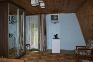 ein Wohnzimmer mit einem TV an der Wand in der Unterkunft Гостевой дом Приморская 7 in Satoka