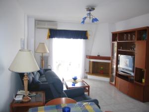 uma sala de estar com um sofá e uma televisão em Seaside Modern Apartment - Explore Athens and Beyond em Porto Rafti