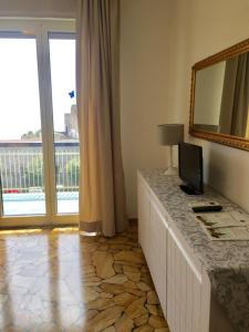 a bed sitting in front of a window next to a window at Park Hotel Castello in Finale Ligure