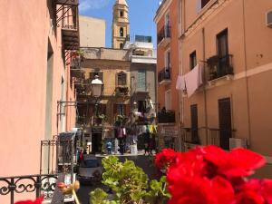 - une vue sur une rue de la ville ornée de fleurs rouges dans l'établissement Loft delizioso, à Cagliari