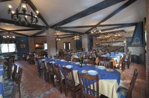 a dining room with blue tables and chairs and a chandelier at Hotel Alonso in Llanes