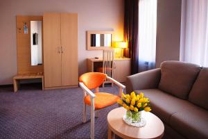 a living room with a couch and a vase of flowers on a table at Krasnodar Aerohotel in Krasnodar