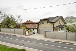 a house on the side of a road with a fence at Hava apartment in Sarajevo