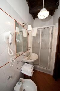 ein Badezimmer mit einem Waschbecken, einem WC und einem Spiegel in der Unterkunft Il Valentino in Castel Gandolfo