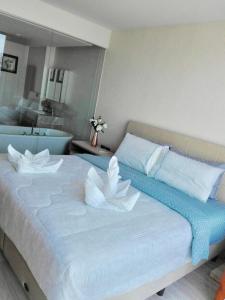 a bedroom with a large bed with white flowers on it at The Pine Hua Hin in Hua Hin