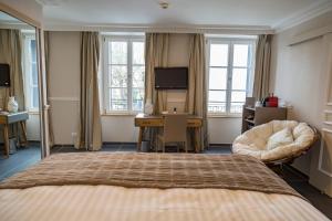 エペルネーにあるホテル ジャン モエのベッド、デスク、窓が備わるホテルルームです。