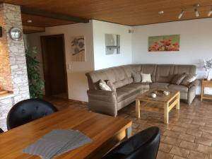 ein Wohnzimmer mit einem Sofa und einem Tisch in der Unterkunft Ferienwohnung Bachem in Hürtgenwald