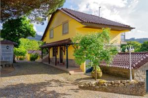 una casa gialla con un sentiero di fronte di Zen Vouga a Ribeiradio