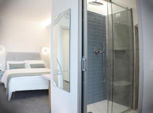 a bathroom with a glass shower and a bed at L'Ancora in Portovenere