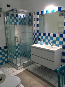 ein Bad mit einer Glasdusche und einem Waschbecken in der Unterkunft B&B Villa Piera Montecucco in Stintino