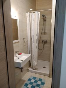 a bathroom with a sink and a shower with a shower curtain at SunStone Court in St Paul's Bay