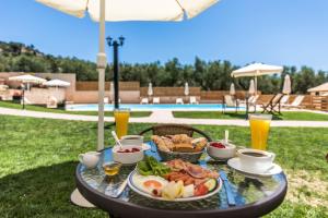 a table with a plate of food and drinks at Dolce Vita Residence in Kalamaki
