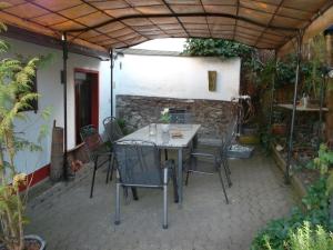een patio met een tafel en stoelen onder een dak bij Ferienhaus-Barz in Treis-Karden