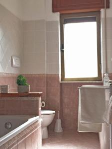 a bathroom with a tub and a toilet and a window at La casa del Professore in Tortora +22 photos