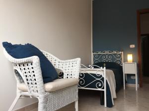 a room with a wicker chair and a bed at La casa del Professore in Tortora