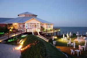 a large building with tables and chairs in front of the ocean at Edificio Waikiki in Mar del Plata