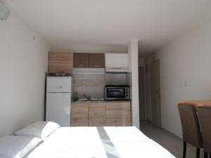 a small kitchen with a bed and a microwave at Apartments Dragan in Kotor