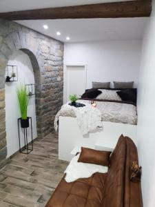 ein Schlafzimmer mit einem Bett und einer Steinmauer in der Unterkunft Studio Koper in Koper