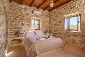 Villa Katerina في كالاماكي: غرفة نوم بسرير وجدار حجري