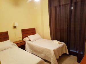 A bed or beds in a room at Apartamentos Olympia Center