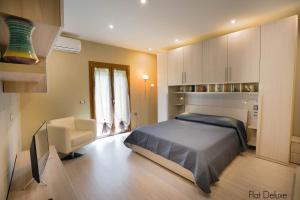 um quarto com uma cama e uma cadeira em Luxury Home Garden Apartment Bosa Marina em Bosa Marina