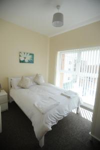 a white bed in a room with a window at Liverpool 2 Bedroom Apartment in Liverpool